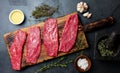 Fresh raw meat beef steaks. Beef tenderloin on wooden board, spices, herbs, oil on slate gray background. Food cooking background Royalty Free Stock Photo