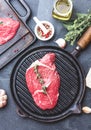 Fresh raw meat. Beef Tenderloin and marbled beef steaks on grill pan and frying board with seasoning, black background top view Royalty Free Stock Photo
