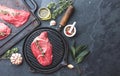 Fresh raw meat. Beef Tenderloin and marbled beef steaks on grill pan and frying board with seasoning, black background top view Royalty Free Stock Photo