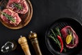 Fresh raw meat. Beef Tenderloin and marbled beef steaks on grill pan and frying board with seasoning, black background