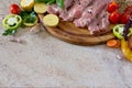 Fresh raw meat pork tenderloin with vegetables on a cutting board. Royalty Free Stock Photo