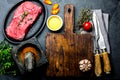 Fresh raw meat steak beef tenderloin, herbs and spices around cutting board. Food cooking background with copy space Royalty Free Stock Photo