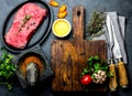 Fresh raw meat steak beef tenderloin, herbs and spices around cutting board. Food cooking background with copy space Royalty Free Stock Photo