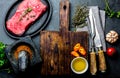 Fresh raw meat steak beef tenderloin, herbs and spices around cutting board. Food cooking background with copy space Royalty Free Stock Photo