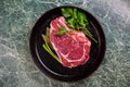 Fresh Raw Meat for Steak Ribeye, Decorated with Herbs and Sprinkled with Spices and Coarse Salt, Lies in a Cast-Iron Vintage Pan. Royalty Free Stock Photo