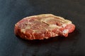 Fresh and raw meat. Whole piece of red meat ready to cook on the grill or BBQ . Background black blackboard Royalty Free Stock Photo