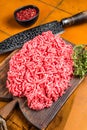 Fresh Raw Mince, Ground beef and pork meat on a butcher board. Orange background. Top view Royalty Free Stock Photo