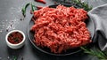 Fresh Raw mince, Minced beef, ground meat with herbs and spices on black plate