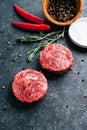 Fresh raw minced beef steak for burgers on black background with rosemary, chili pepper and spice Royalty Free Stock Photo