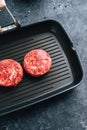 Fresh raw minced beef steak for burgers on black grill pan Royalty Free Stock Photo