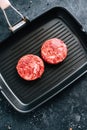 Fresh raw minced beef steak for burgers on black grill pan Royalty Free Stock Photo