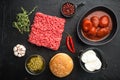 Fresh raw minced beef steak burgers with spices ingredients, on black stone background, top view flat lay Royalty Free Stock Photo