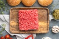 Fresh raw minced beef steak burgers with spices ingredients, on wooden tray, on gray stone background, top view flat lay Royalty Free Stock Photo