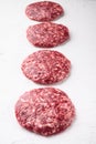 Fresh raw minced homemade farmers beef burgers cutlets, on white stone  background Royalty Free Stock Photo