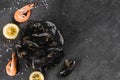 Fresh raw mussels in fishing net with seaweed and shrimp with slice of lemon on dark stone background. Seafood, Shellfish Royalty Free Stock Photo