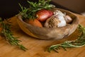 Fresh raw onions, garlic, rosemary closeup in wooden bowl Royalty Free Stock Photo