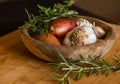 Fresh raw onions, garlic, rosemary closeup in wooden bowl Royalty Free Stock Photo