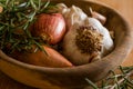 Fresh raw onions, garlic, rosemary closeup in wooden bowl Royalty Free Stock Photo