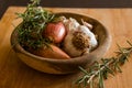 Fresh raw onions, garlic, rosemary closeup in wooden bowl Royalty Free Stock Photo