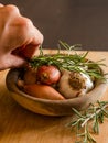 Fresh raw onions, garlic, rosemary closeup in wooden bowl Royalty Free Stock Photo