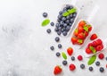 Fresh raw organic berries in white scoop spoon on kitchen table background. Space for text. Top view. Strawberry, Raspberry, Blueb Royalty Free Stock Photo