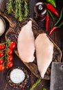 Fresh Raw Organic Chicken Fillet Breast on vintage board with meat hatchets and hammer with spices and herbs on wooden background