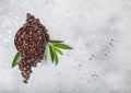 Fresh raw organic coffee beans with coffee trea leaf on light kitchen table background