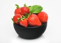 Fresh raw organic strawberries in black ceramic bowl plate on white background. Best summer berries Royalty Free Stock Photo