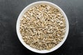 Fresh raw organic sunflower seeds in a white round bowl on a table in soft focus, isolated on black, top view or flat lay of healt Royalty Free Stock Photo