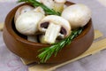 Fresh raw organic white champignon mushrooms in brown wooden bowl on the table background. Royalty Free Stock Photo