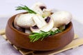 Fresh raw organic white champignon mushrooms in round wooden bowl on table background. Royalty Free Stock Photo