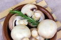 Fresh raw organic white champignon mushrooms in round wooden bowl on table background. Royalty Free Stock Photo