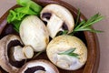 Fresh raw organic white champignon mushrooms in round wooden bowl on table background. Royalty Free Stock Photo