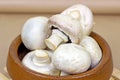 Fresh raw organic white champignon mushrooms in the wooden bowl on table background. Royalty Free Stock Photo