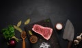 Fresh raw piece of beef meat, striploin steak on a black background, top view. Marbled piece of meat New York