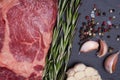 A fresh raw piece of black angus marbled meat with spices close-up on a stone dark background. Ribeye steak Royalty Free Stock Photo