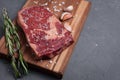 A fresh raw piece of black angus marbled meat with spices close-up on a stone dark background. Ribeye steak Royalty Free Stock Photo