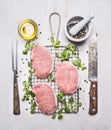 Fresh raw pork steaks with herbs, a knife and fork for the meat on the grill for roasting wooden rustic background top view Royalty Free Stock Photo