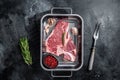 Fresh Raw porterhouse T bone beef meat Steak in steel tray with herbs. Black background. Top view Royalty Free Stock Photo