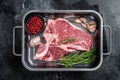 Fresh Raw porterhouse T bone beef meat Steak in steel tray with herbs. Black background. Top view Royalty Free Stock Photo