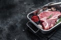 Fresh Raw porterhouse T bone beef meat Steak in steel tray with herbs. Black background. Top view. Copy space Royalty Free Stock Photo