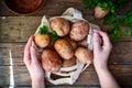 Fresh raw potatoes in a linen bag on a wooden background. Top view. Vegetables. Free space for text. Woman holds potatoes in a