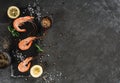 Fresh raw prawns or boiled red shrimps with spices and lemon on slate stone on dark stone background. Seafood, top view, flat lay Royalty Free Stock Photo