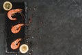 Fresh raw prawns or boiled red shrimps with spices on slate stone on dark stone background. Seafood, top view, flat lay Royalty Free Stock Photo