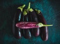 Fresh raw purple and striped eggplants, different color and variety on the dark background