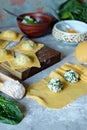 Fresh Raw Ravioli with Ricotta and Spinach on a blue background. Homemade raw uncooked italian pasta ravioli. Royalty Free Stock Photo