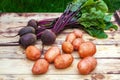 Fresh raw red potatoes and beets on wooden board Royalty Free Stock Photo