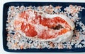 Fresh raw red salmon steak with large coarse pink salt prepared for baking on the grill lies on a blue plate. Healthy seafood food Royalty Free Stock Photo