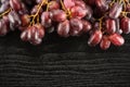 Fresh raw red wine grapes on black wood