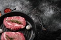 Fresh raw Rib eye Steak with seasonings, on black dark stone table background, with copy space for text Royalty Free Stock Photo